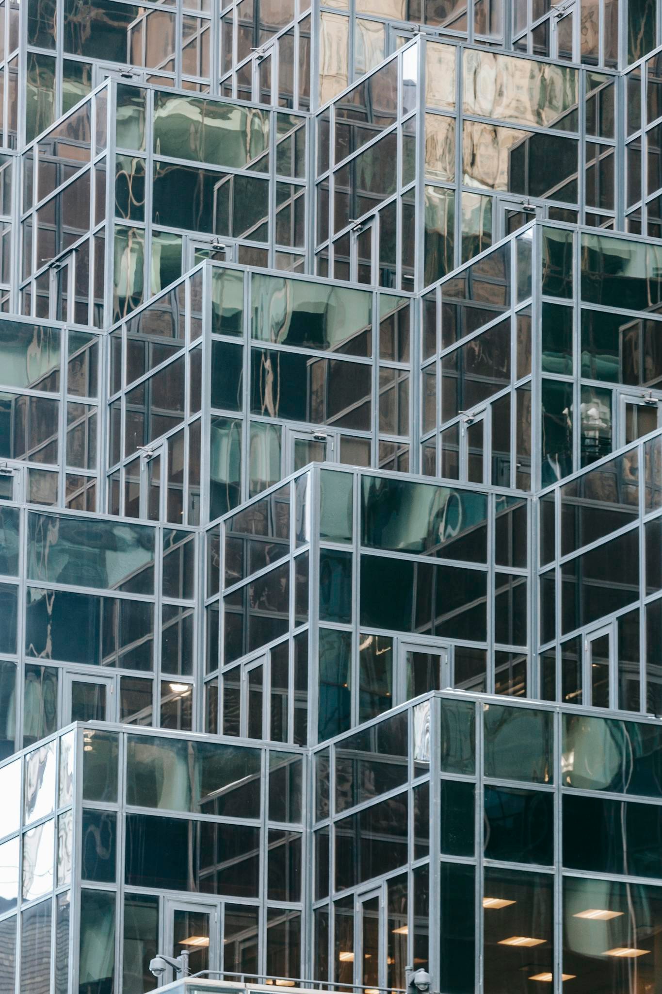 Full frame of contemporary financial skyscraper with geometric glass mirrored walls in daytime